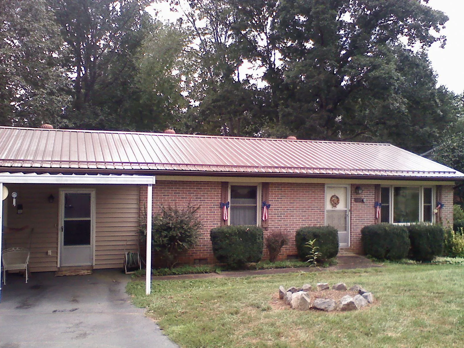 Bronze metal roof and carport on a brick ranch home — Roof Repair work by our crew in Granby
